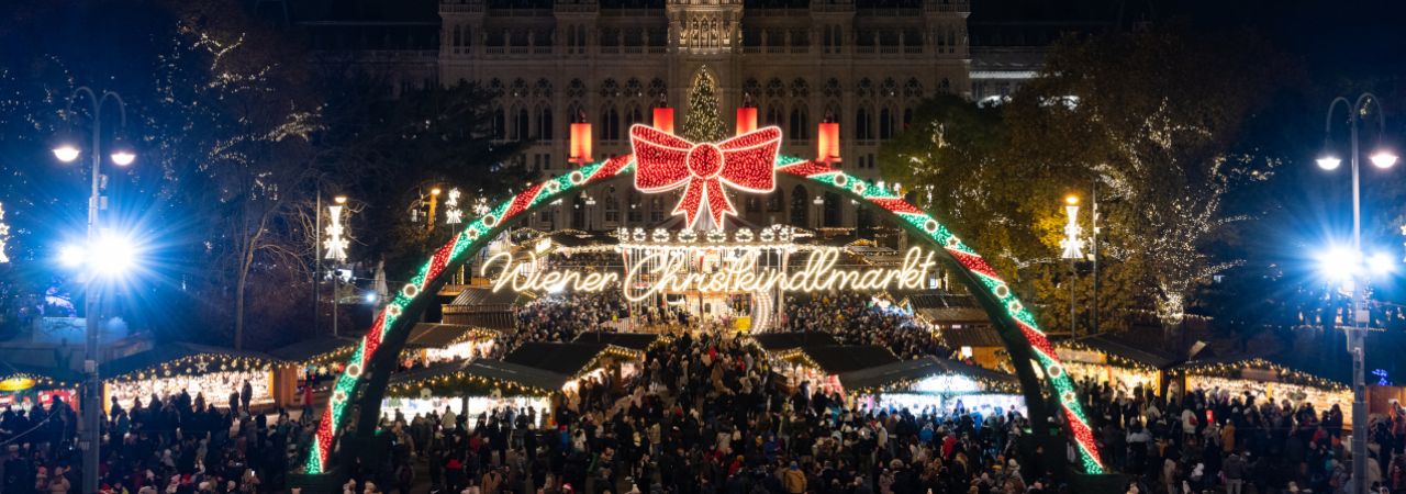 Wiener Christklindlmarkt mit Besucher*innen, vom Burgtheater aus gesehen.